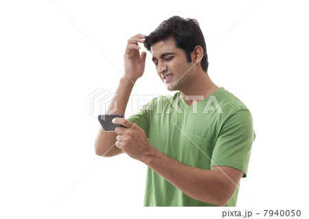 Frustrated man with cellular phone on white background 7940050