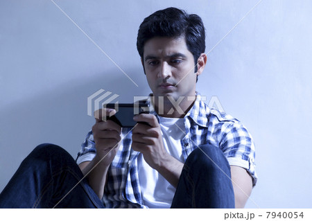 Serious young man reading text message 7940054