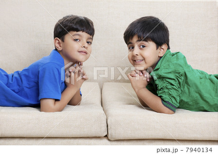 Cute little boys lying on sofa Cute little boys lying on sofa 7940134