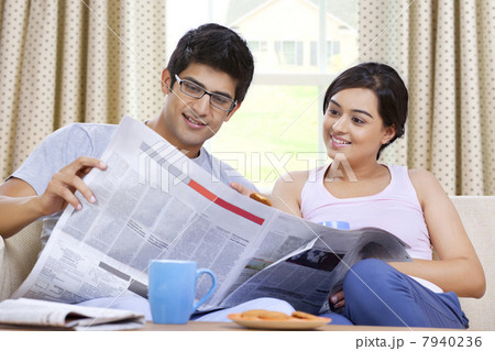 Young couple reading newspaper together 7940236