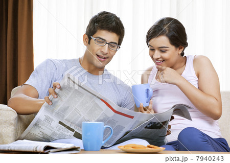 Young couple having coffee while reading newspaper 7940243
