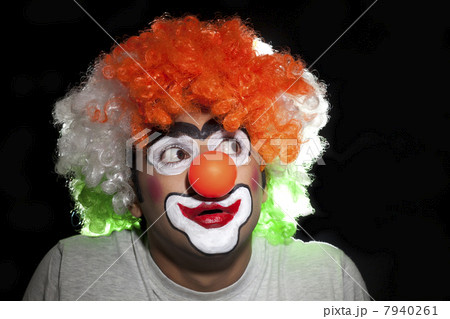 Close-up of young joker staring over black background 7940261