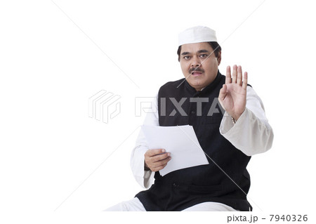 Male politician gesturing while reading document 7940326