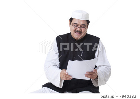 Politician in traditional clothes reading documents 7940332