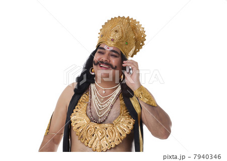 Man dressed as Raavan talking on a mobile phone 7940346