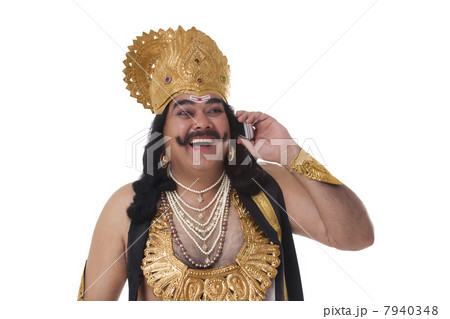 Man dressed as Raavan talking on a mobile phone 7940348