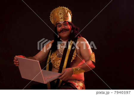 Portrait of a man dressed as Raavan with a laptop Portrait of a man dressed as Raavan with a laptop 7940397