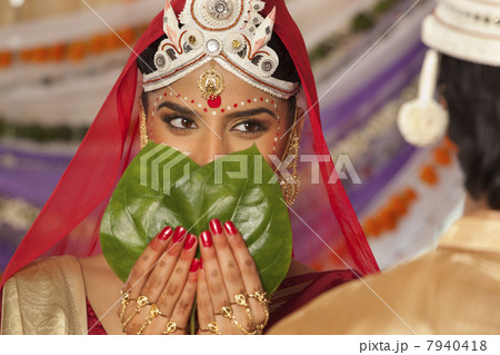 Bengali bride hiding her face from the groom 7940418