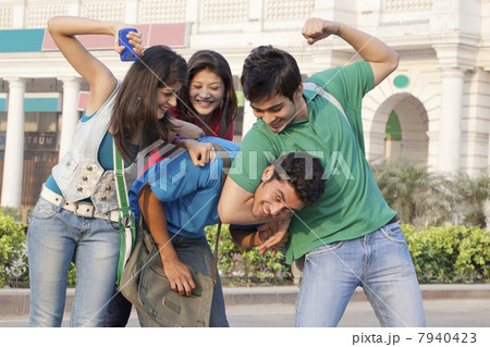 Happy college students having fun with building in the background Happy college students having fun with building in the background 7940423