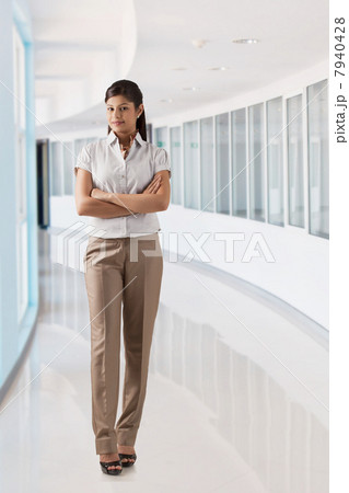 Full length of successful young businesswoman with arms crossed Full length of successful young businesswoman with arms crossed 7940428