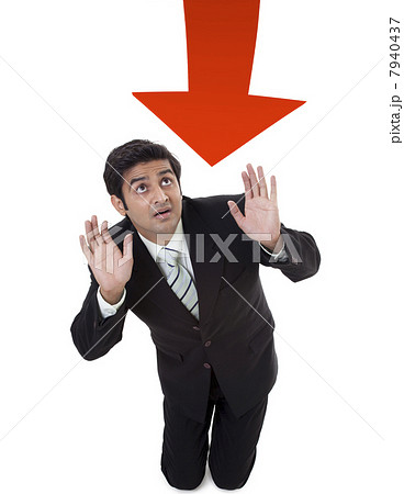 Young businessman protecting himself from arrow sign 7940437