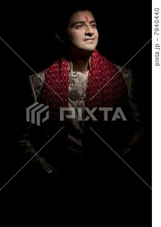 Handsome young groom in sherwani smiling 7940440