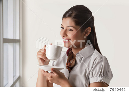 Thoughtful businesswoman having cup of tea for refreshment 7940442