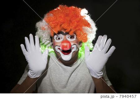 Close-up of male clown performing over black background 7940457