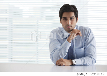 Portrait of successful businessman sitting in office 7940545