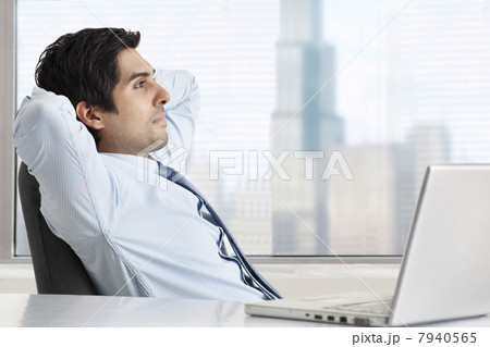 Side view of thoughtful businessman relaxing at his desk 7940565