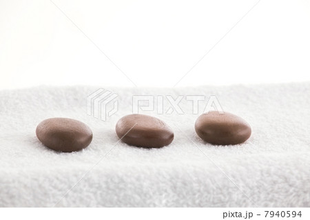 Massage stones in a row on a towel 7940594