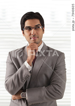 Handsome young businessman thinking at office 7940605