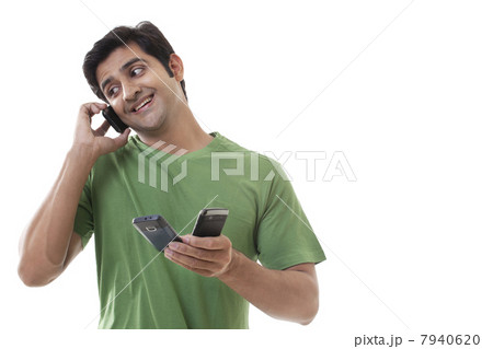 Handsome man holding cell phones while on call 7940620