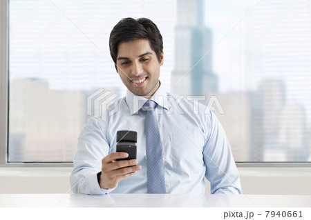 Happy young businessman texting message through cell phone 7940661