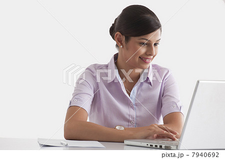 Smiling young businesswoman using laptop Smiling young businesswoman using laptop 7940692