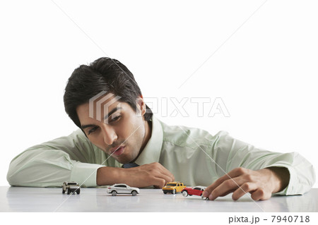 Happy male executive playing with model car 7940718