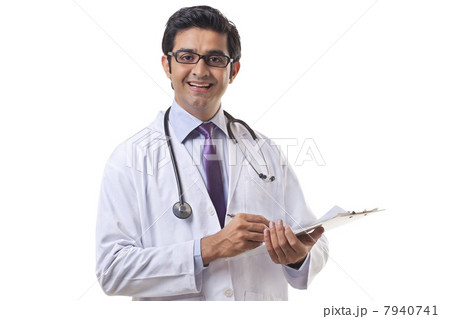 Portrait of male doctor writing on clipboard over white background 7940741