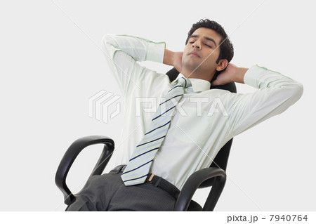 Handsome young businessman relaxing on chair 7940764