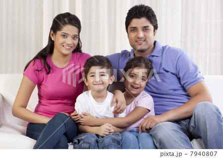 Portrait of happy family sitting on sofa 7940807