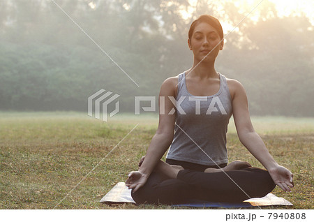 Young woman meditating in park 7940808