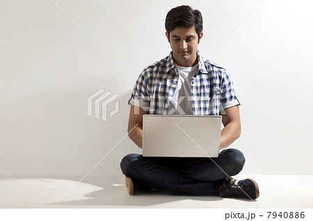 Full length of handsome man using laptop 7940886