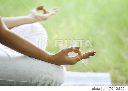 Young woman meditating in lawn Young woman meditating in lawn 7940892