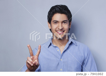 Portrait of young man showing V-sign Portrait of young man showing V-sign 7941002