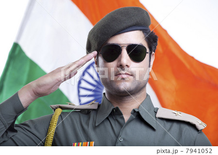 Close-up of a security guard saluting with Indian flag in the background 7941052
