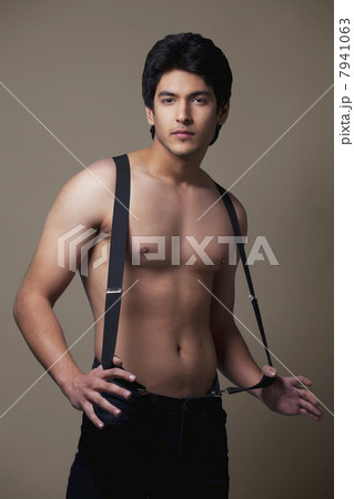 Portrait of shirtless man wearing suspenders 7941063