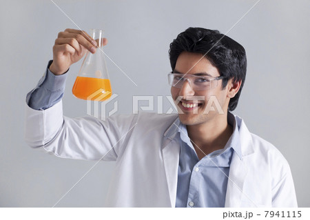 Portrait of scientist smiling and holding flask 7941115