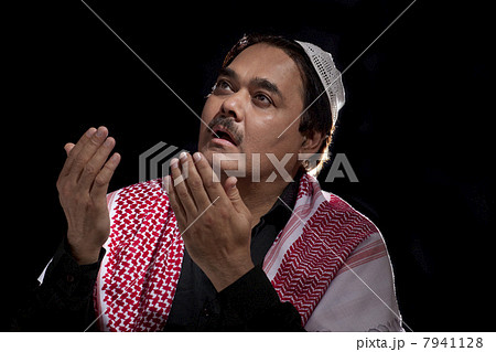 Mature man in traditional dress praying Mature man in traditional dress praying 7941128