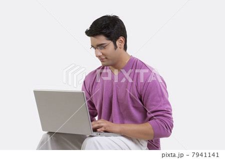 Young man using laptop over white background 7941141