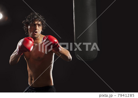Male boxer about to hit punching bag Male boxer about to hit punching bag 7941285