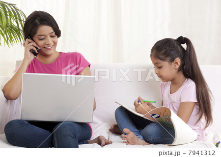 Happy woman on call while daughter holding felt tip pen 7941312