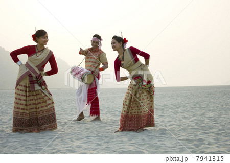 Bihu women dancing as Bihu man plays on a dhol 7941315