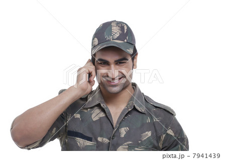 Smiling young soldier having conversation on mobile phone over white background 7941439