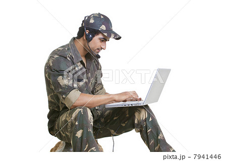 Young soldier using laptop over white background Young soldier using laptop over white background 7941446
