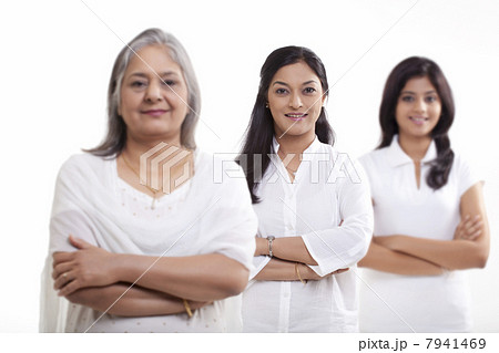 Multi generation family with arms crossed over white background 7941469