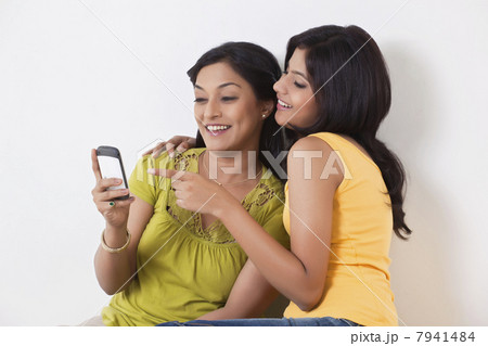 Teenage girl pointing on mobile phone 7941484