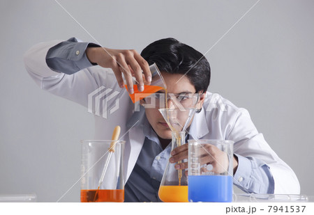 Scientist pouring liquid into flask Scientist pouring liquid into flask 7941537