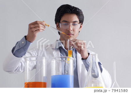 Lab technician adding solution to test tube 7941580