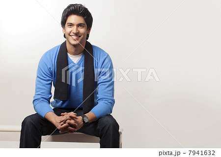 Smart young man sitting over colored background 7941632