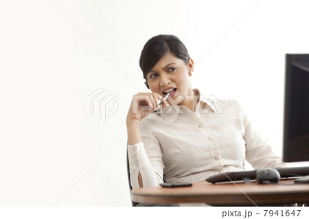 Businesswoman on call while looking at computer Businesswoman on call while looking at computer 7941647