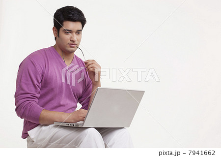 Serious young man using laptop 7941662